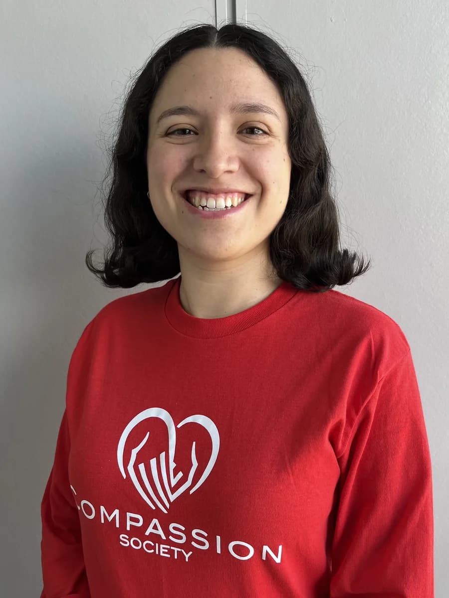 Portrait of Nancy Recalde, Administrative Coordinator at Compassion Society of Halton, smiling in a red Compassion Society shirt.